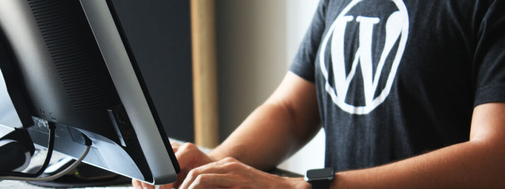 Guy in WordPress T-shirt sitting in front of computer